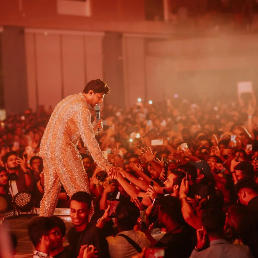 SIDE OF THE SATEG,SINGER SHAKING HANDS WITH THE CROWD,ORANGE LIGHTS